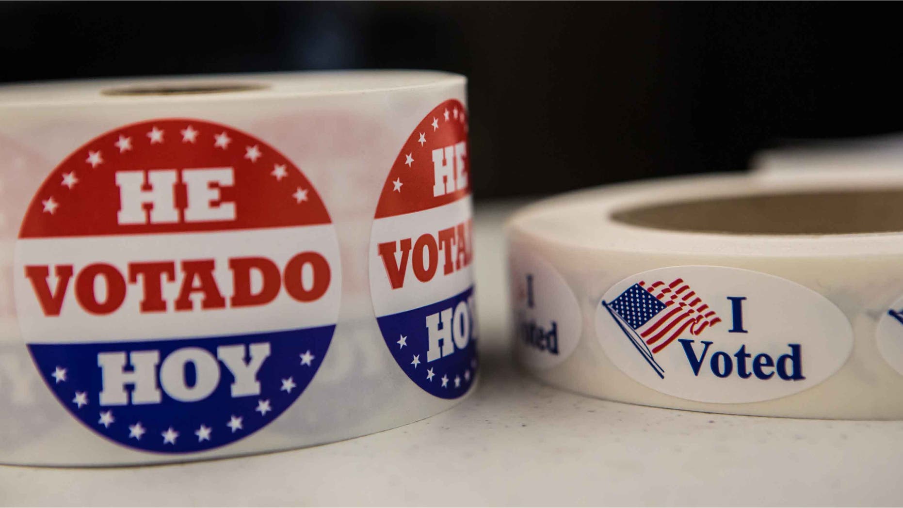 WASHINGTON - NOVEMBER 6: Stickers in English and Spanish are available for voters at the Martin Luther King, Jr. Memorial Library on Tuesday, November 6, 2012 in Washington, DC. The latest polls continue to show a tight race between President Barack Obama and Republican challenger Mitt Romney. (Photo by Brendan Hoffman/Getty Images)