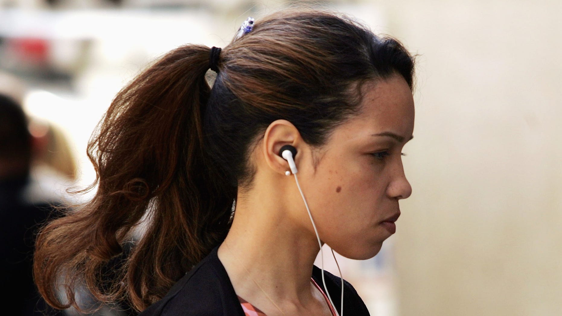 NEW YORK - APRIL 19: A woman walks down the street with the white headphones of the Apple iPod ion her ears April 19, 2005 in New York City. iPods, along with cell phones and other electronic devices, are blamed for a surge in subway crime in New York City and thefts in general in other U.S. cities. (Photo by Spencer Platt/Getty Images)
