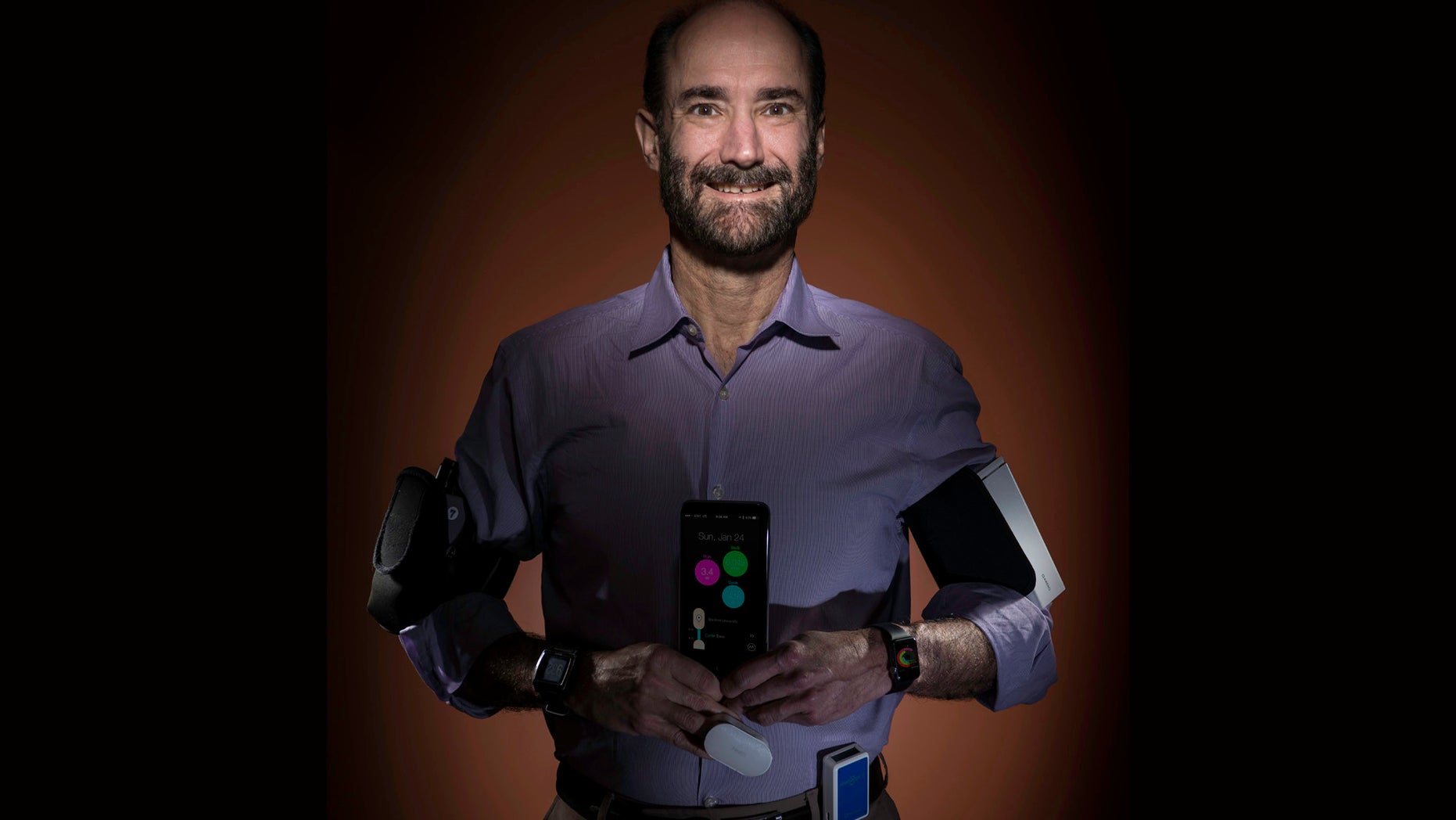 In this photo provided by Steve Fisch, Michael Snyder, professor and chair of genetics at the Stanford University School of Medicine sports wearable gadgets. Wearable gadgets gave a Snyder an early warning that he was getting sick before he ever felt any symptoms of Lyme disease. (Steve Fisch via AP)