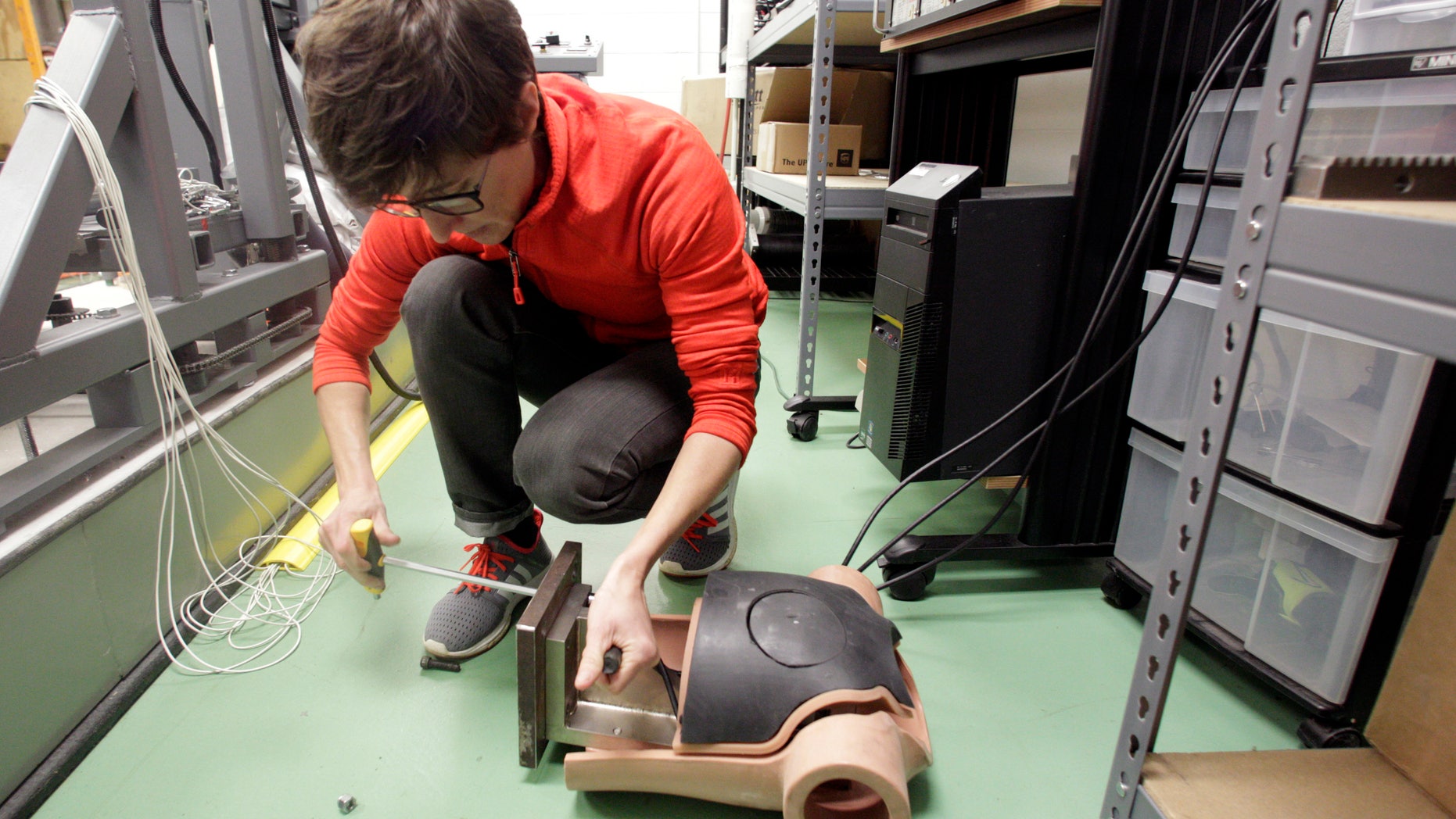 In this March 17, 2016 photo, Elizabeth McCalley prepares a dummy for testing the impact of a ball to a person's chest at the National Operating Committee on Standards for Athletic Equipment facility in Rockford, Tenn.