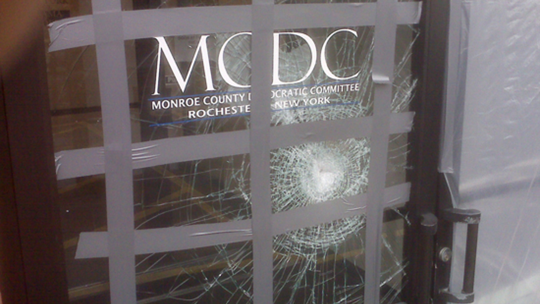 This picture provided on Wednesday, March 24, 2010 by the Monroe County Democratic Committee in Rochester, N.Y. shows damage to their office after a glass door was struck with a brick with a note reading "Exremism in Defense of Liberty Is no Vice" sometime from late Saturday, March 20, 2010 or Sunday, March 21, 2010.(AP)