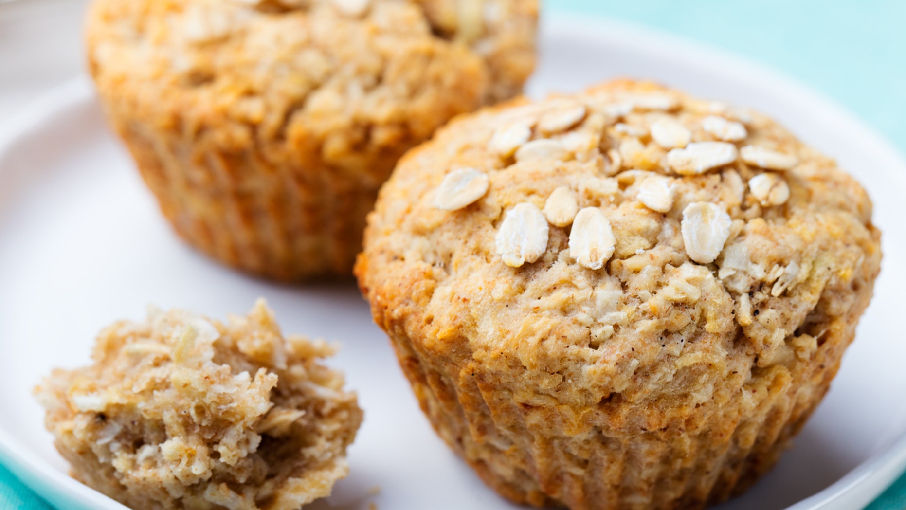 Healthy vegan oat muffins, apple and banana cakes with sour cream on a white plate Blue stone background