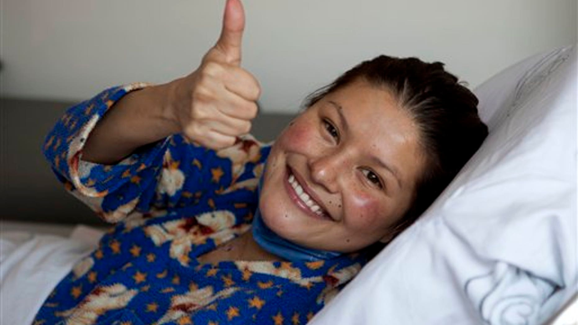 Erika Hernandez, 28, gives a thumbs up from inside an ambulance after being discharged from the hospital where she had a heart transplant in Mexico City, Tuesday Jan. 24, 2012. Hernandez made national news on Jan. 11 when her new heart was accidentally dropped while being transported to the hospital where she was waiting for surgery.