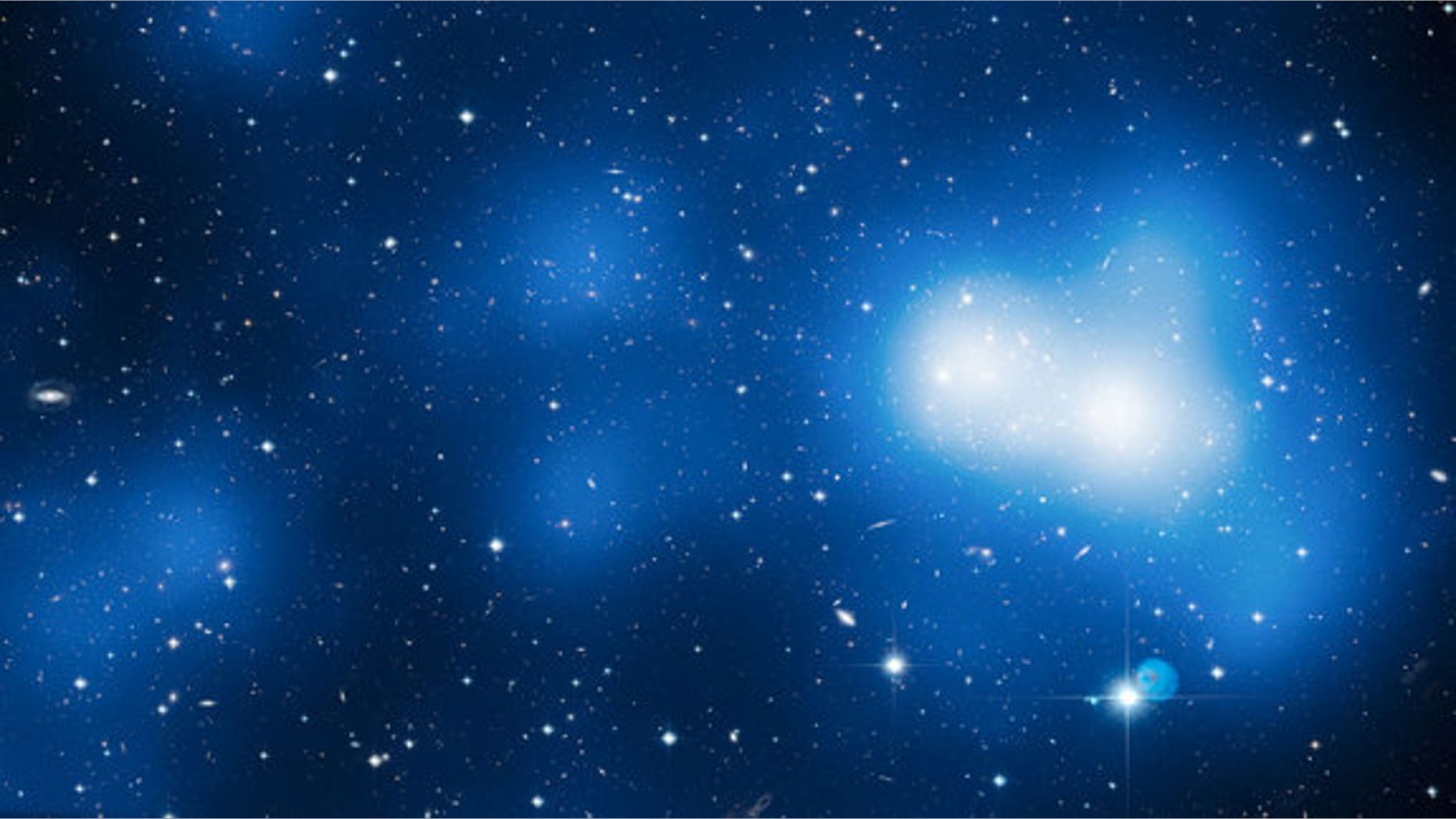 This enormous image shows Hubble’s view of massive galaxy cluster MACS J0717. The large field of view is a combination of 18 separate Hubble images. The location of the dark matter is revealed in a map of the mass in the cluster and surrounding