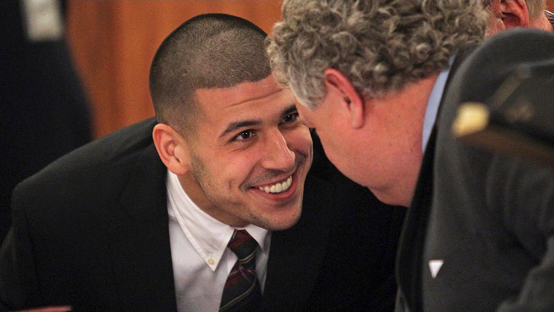 FILE 2013: Former New England Patriots player Aaron Hernandez smiles at his defense attorney Michael Fee as he appears in court at the Fall River Justice Center in Fall River, Mass.
