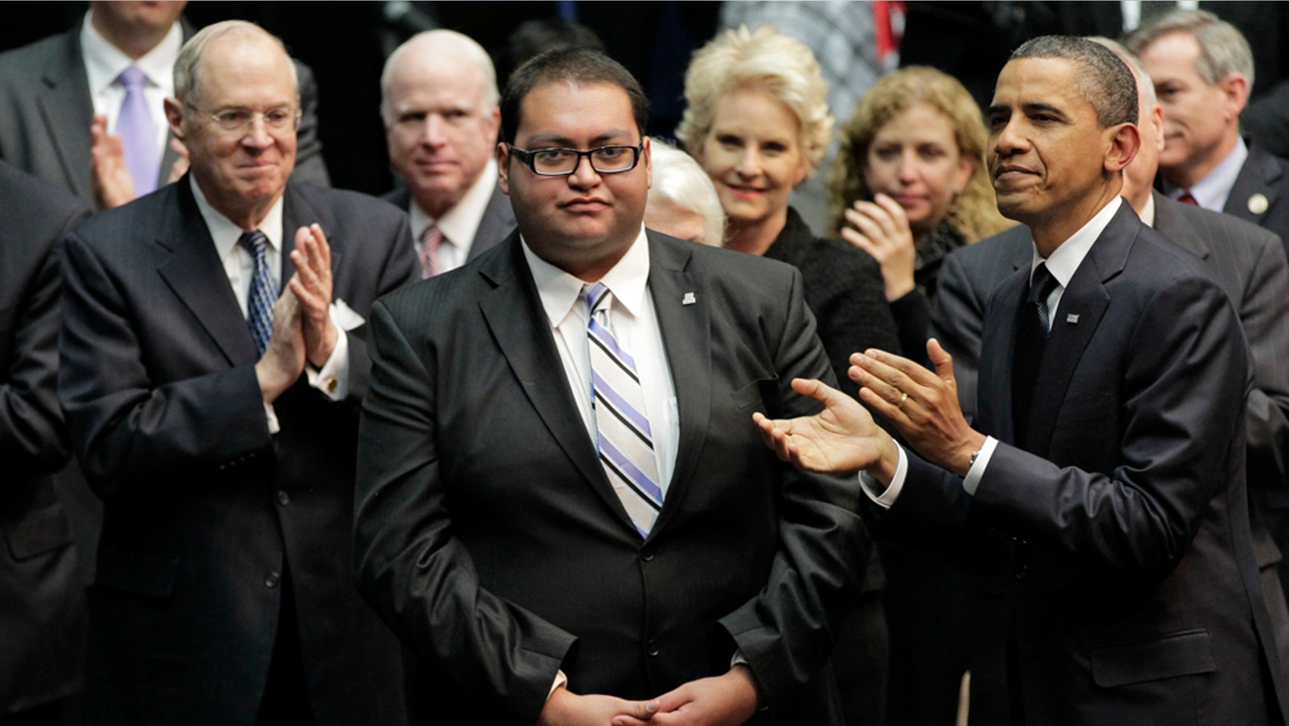 FILE - In this Jan. 12, 2011 file photo, Daniel Hernandez Jr., center, who was with Rep. Gabrielle Giffords when she was shot, receives a standing ovation, during President Obama's visit to speak in Tucson, Ariz., in the wake of the mass shooting. A White House official says Hernandez will sit with first lady Michelle Obama Tuesday night for President Barack Obama's State of the Union address. (AP Photo/J. Scott Applewhite, File)