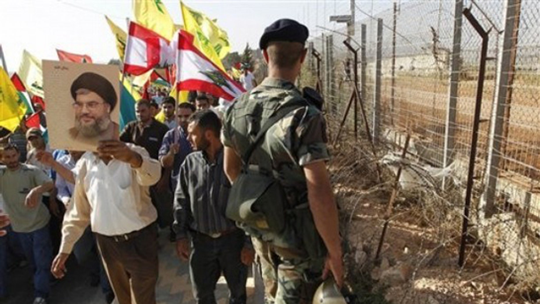 June 2: A Hezbollah supporter holds up a poster of Hezbollah leader Sheik Hassan Nasrallah as he protests with others along the Lebanese-Israeli border in southern Lebanon.