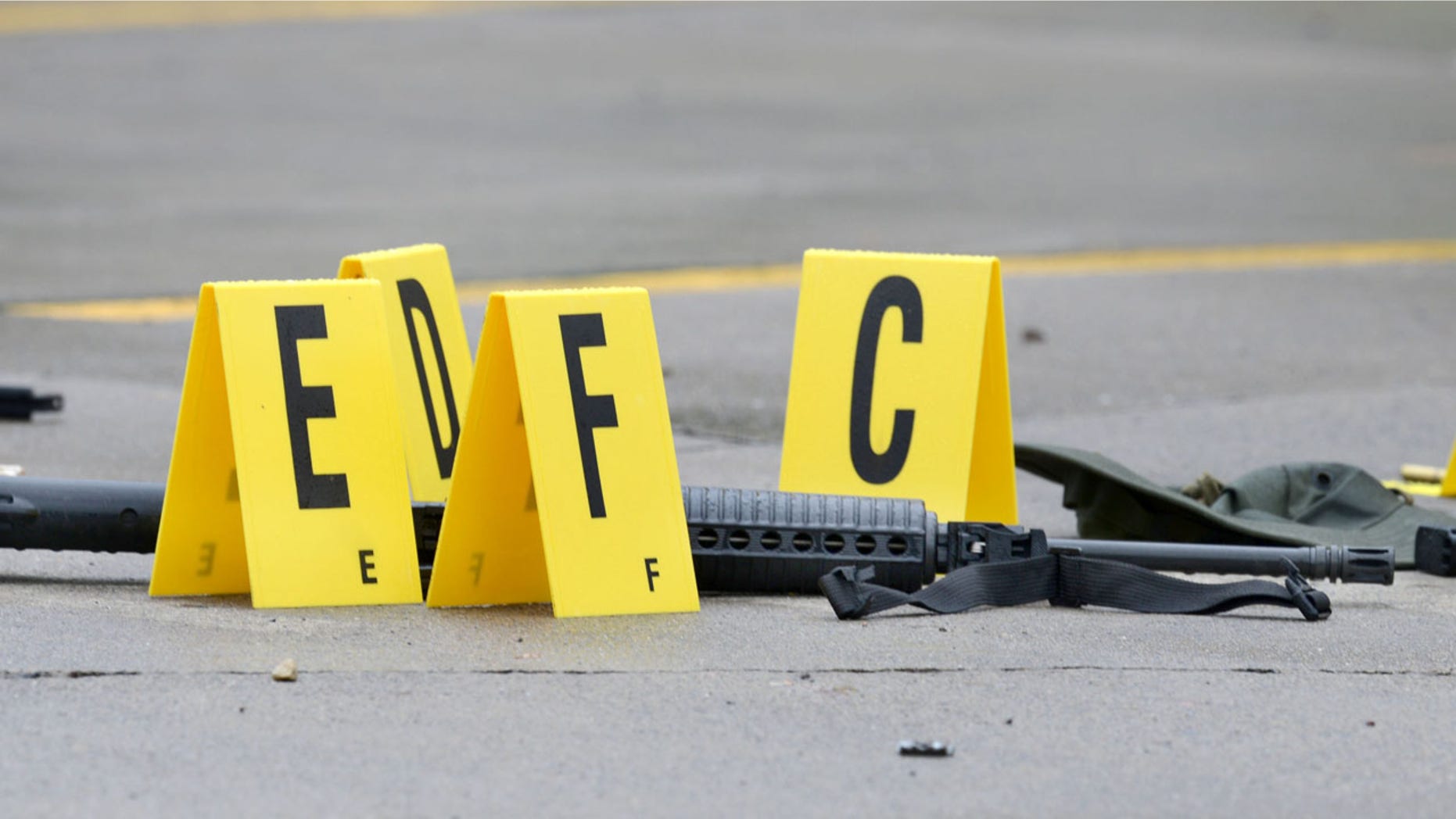 July 7, 2016: A weapon lays on the ground next to evidence markers in Bristol, Tenn. Three people were injured and one person was killed after a man opened fire on motorists traveling along a parkway in East Tennessee.