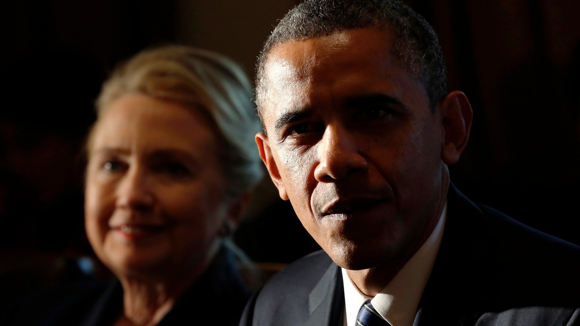 FILE -- President Barack Obama speaks during a meeting with members of his cabinet at the White House in Washington Nov. 28, 2012. Seated beside him is Secretary of State Hillary Clinton. (REUTERS/Kevin Lamarque)
