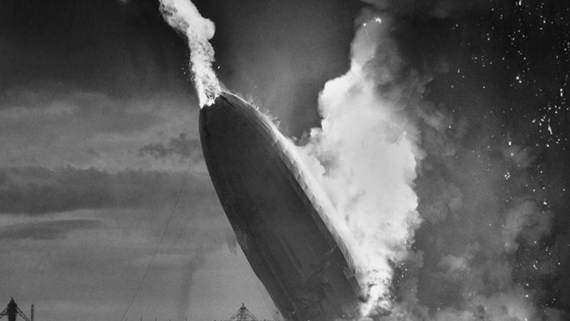 FILE - In this May 6, 1937 file photo, the German dirigible Hindenburg crashes to earth in flames after exploding at the U.S. Naval Station in Lakehurst, N.J. Only one person is left of the 62 passengers and crew who survived when the Hindenburg burst into flames 80 years ago Saturday, May 6, 2017. Werner Doehner was 8 years old when he boarded the zeppelin with his parents and older siblings after their vacation to Germany in 1937. The 88-year-old now living in Parachute, Colo., tells The Associated Press that the airship pitched as it tried to land in New Jersey and that "suddenly the air was on fire." (AP Photo/Murray Becker, File)