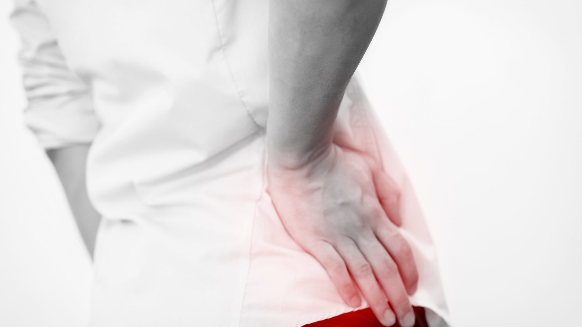 Young man in casual office shirt having hip pain (Focus on hips)