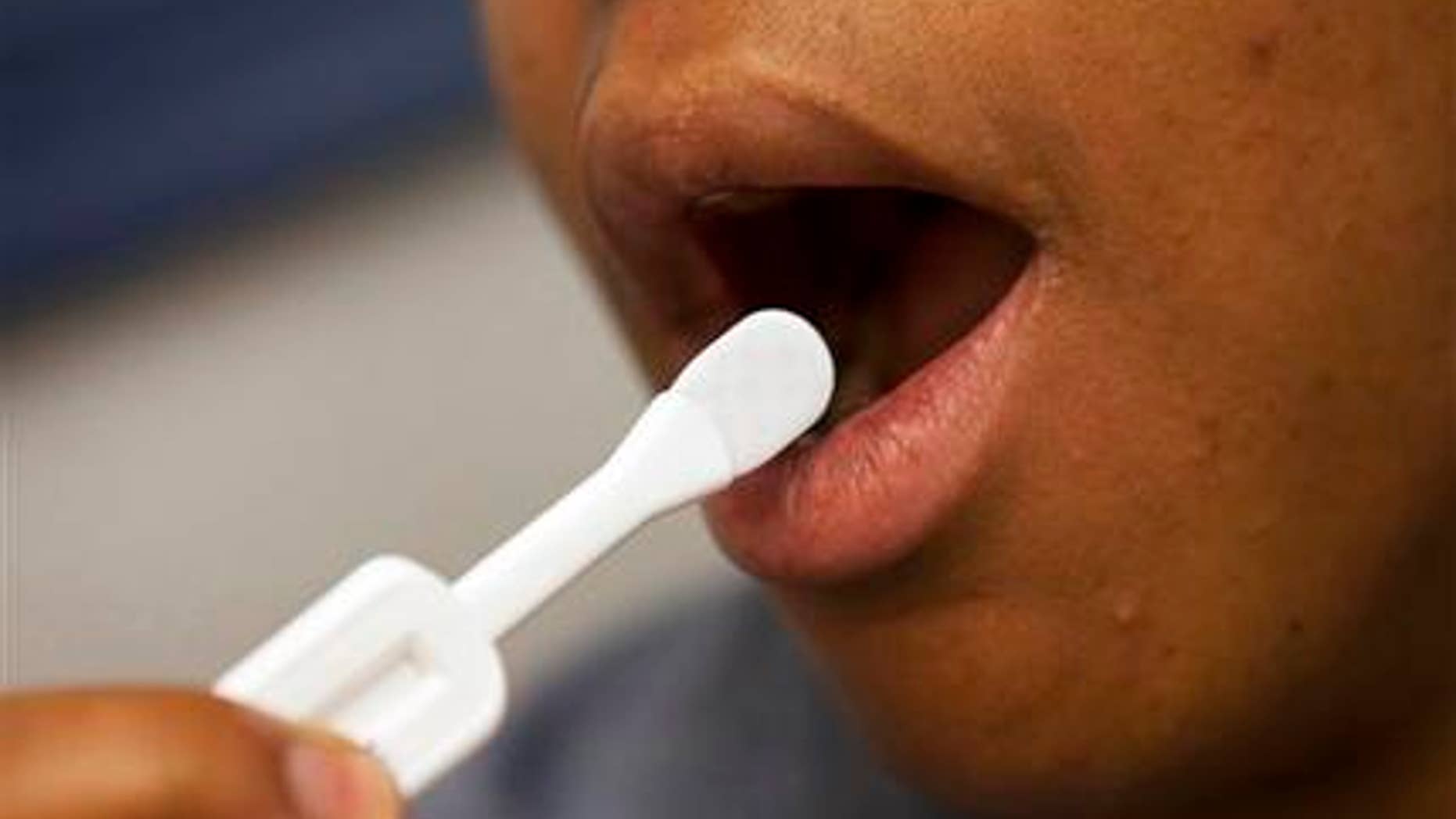 In this photo taken June 27, 2012, Katherine Tapp, 26 of New York City uses an oral test for HIV, inside the HIV Testing Room at the Penn Branch of the District of Columbia Department of Motor Vehicles, in southeast Washington.