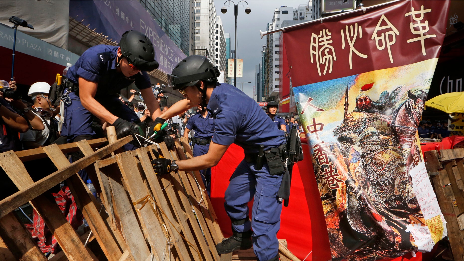 Nov. 26, 2014: Police officers remove the barricades made up mostly of wooden pallets by demonstrators decorated with a banner