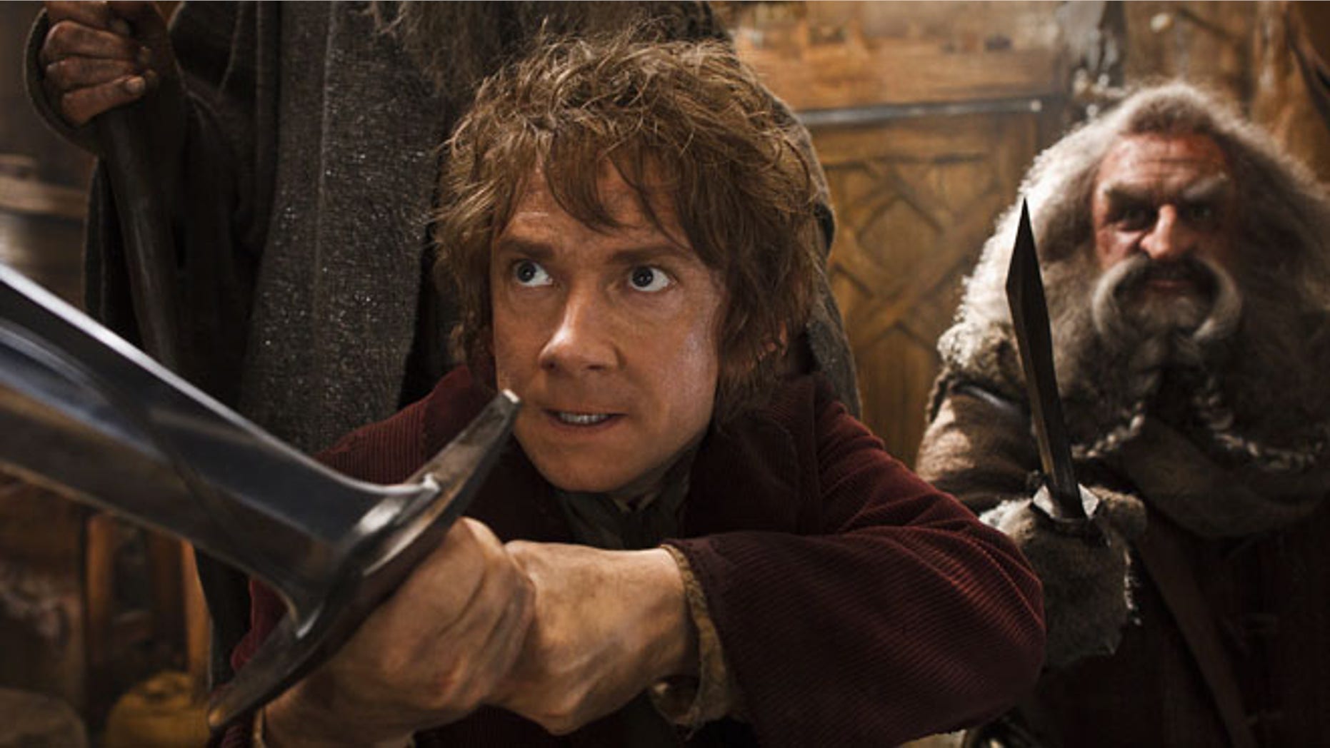 This image released by Warner Bros. Pictures shows Martin Freeman, left, and John Callen in a scene from "The Hobbit: The Desolation of Smaug." The Hobbit: The Desolation of Smaug held off Anchorman 2 on a busy weekend at the box office. According to studio estimates Sunday, Peter Jacksons Hobbit sequel took in $31.5 million in its second weekend of release. That topped Will Ferrells Anchorman sequel, which nevertheless opened strongly in second place.