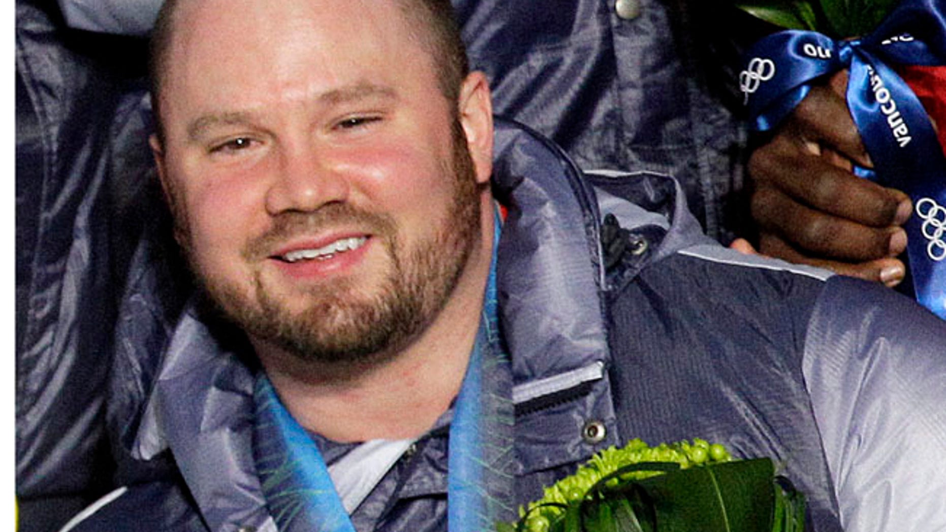 FILE - In this Feb. 27, 2010, file photo, Steven Holcomb, of the United States, poses with his gold medal in the men's four-man bobsled during the medal ceremony at the Vancouver 2010 Olympics in Whistler, British Columbia. Holcomb, the longtime U.S. bobsledding star who drove to three Olympic medals after beating a disease that nearly robbed him of his eyesight, was found dead in Lake Placid, N.Y., on Saturday, May 6, 2017. He was 37. (AP Photo/Jin-man Lee, File)