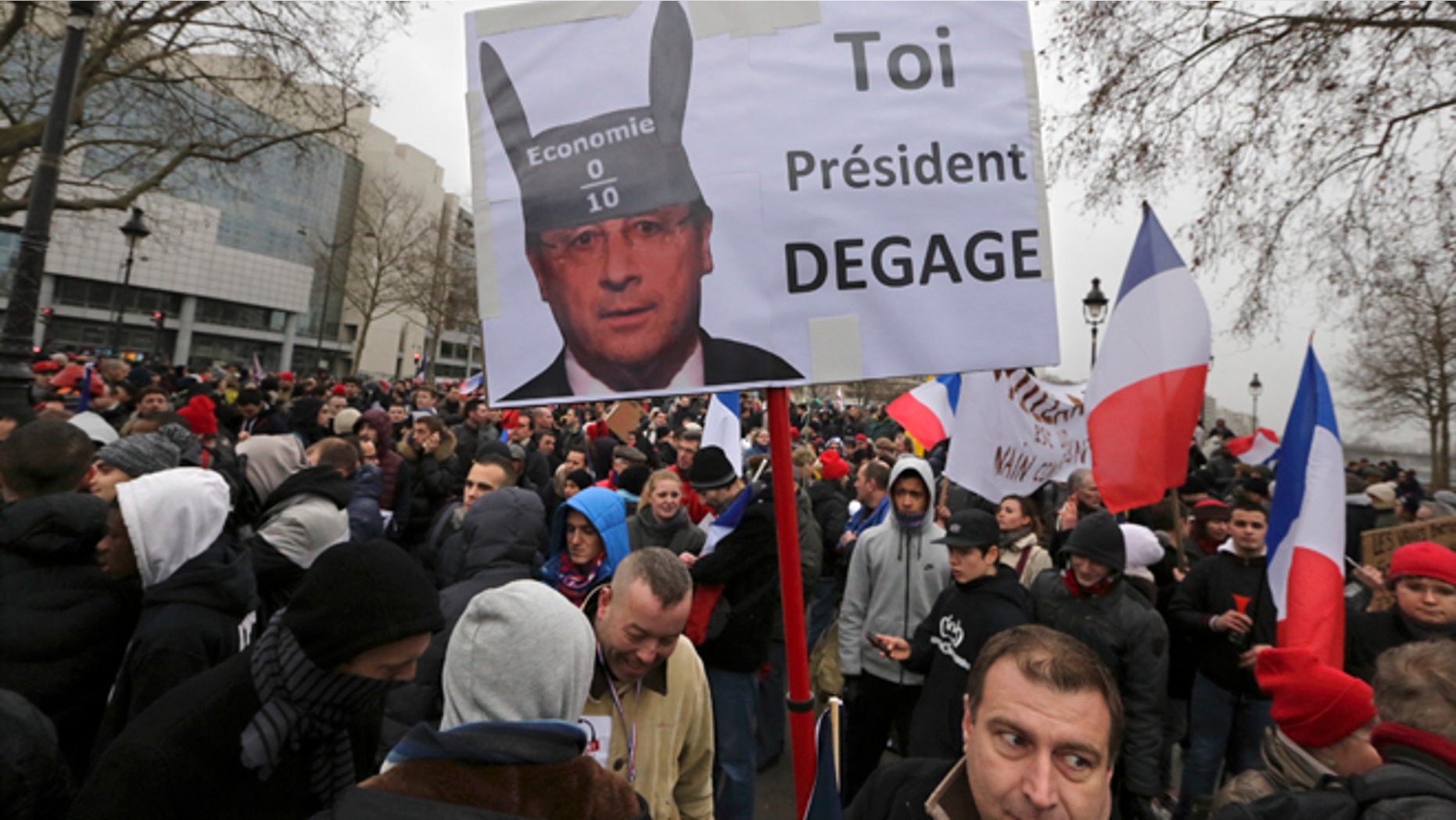 Jan. 26, 2014: Demonstrators gather near a sign portraying French President Francois Hollande wearing donkey ears with a school grade of Zero and which reads "You, President Resign" as several thousand people attend the "Journee de la Colere" (Day of Anger) march in Paris.