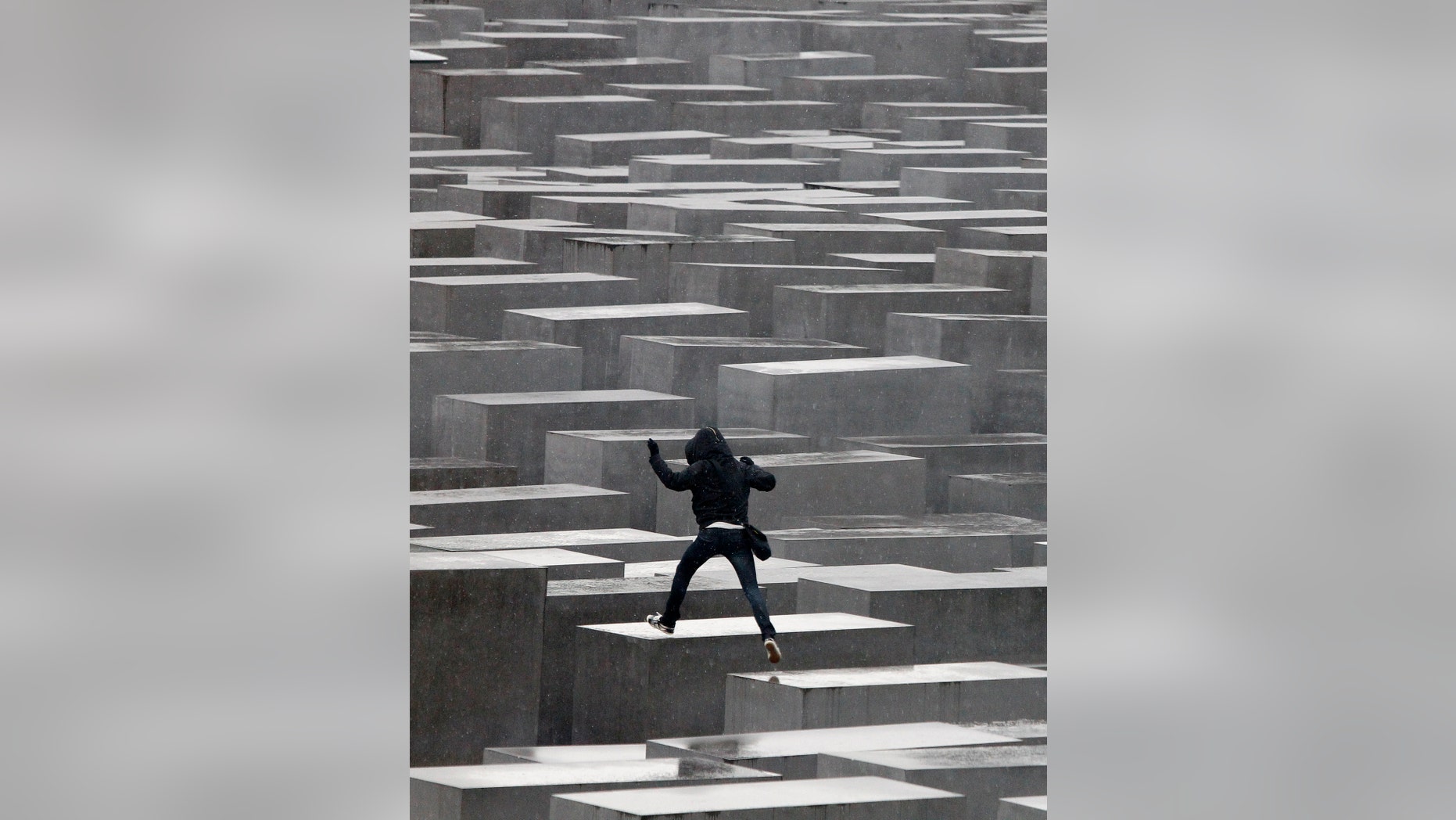 File photo - an unidentified youth jumps from one pillar to another at the Holocaust memorial in Berlin, March 3, 2010. The memorial to the murdered Jews of Europe consists of 2,711 charcoal-grey rectangular pillars, which rise from the ground and form a tight grid through which visitors can wander. (REUTERS/Tobias Schwarz)