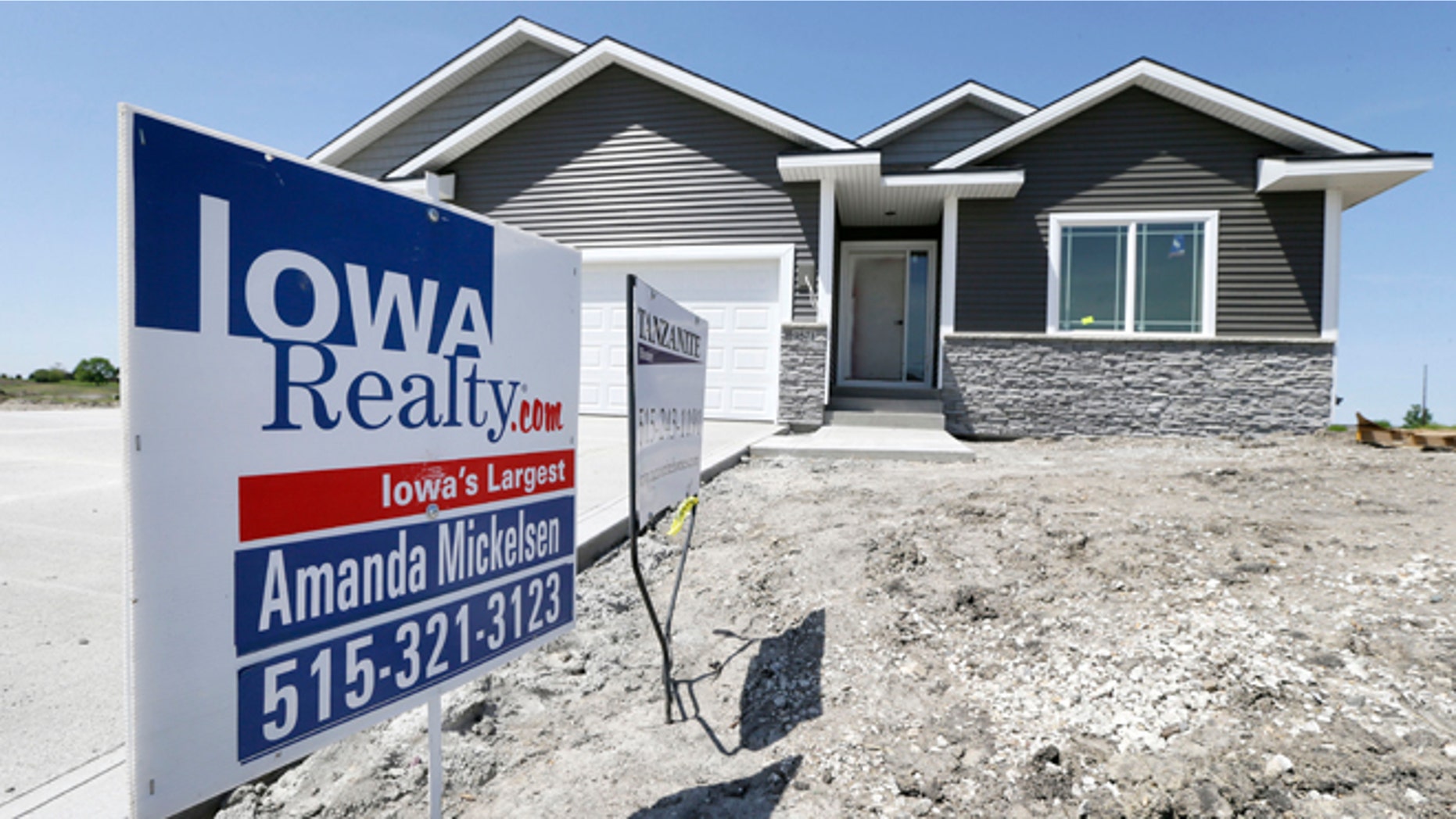 FILE: A sign sits in front of a new home for sale in West Des Moines, Iowa.