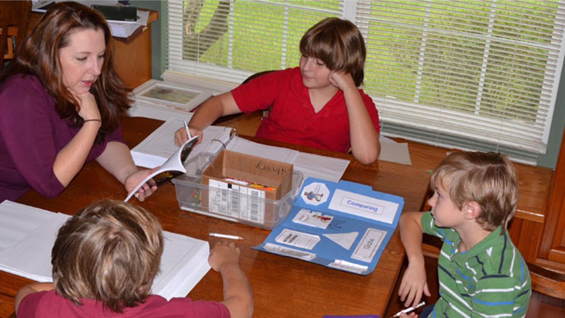 Jill Finnerty Ricardo, of Dade City, Fla., is seen teaching a lesson at home to three of her children, Rhett, 9, Roman, 11, and Reagan, 6.