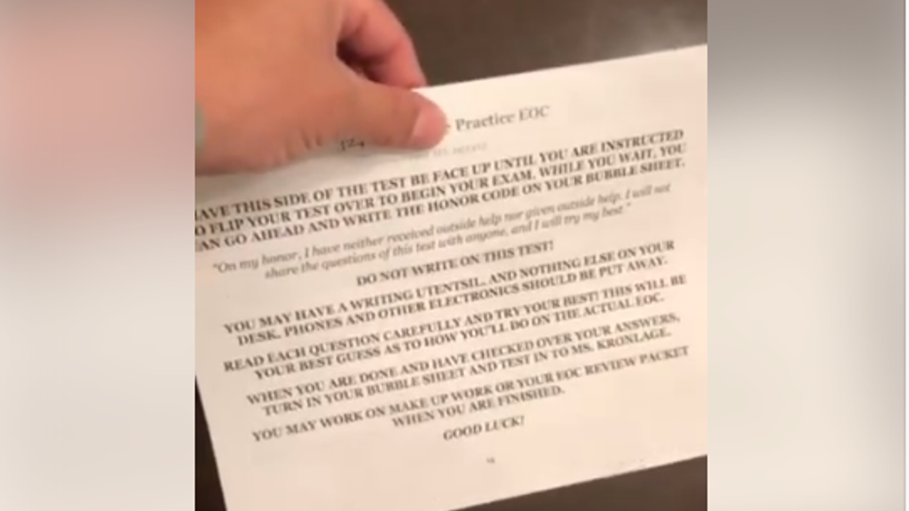 Omar Austin, of Jacksonville, Fla., holds up his teen daughter's practice test, which, he says, contains a sexually explicit question.