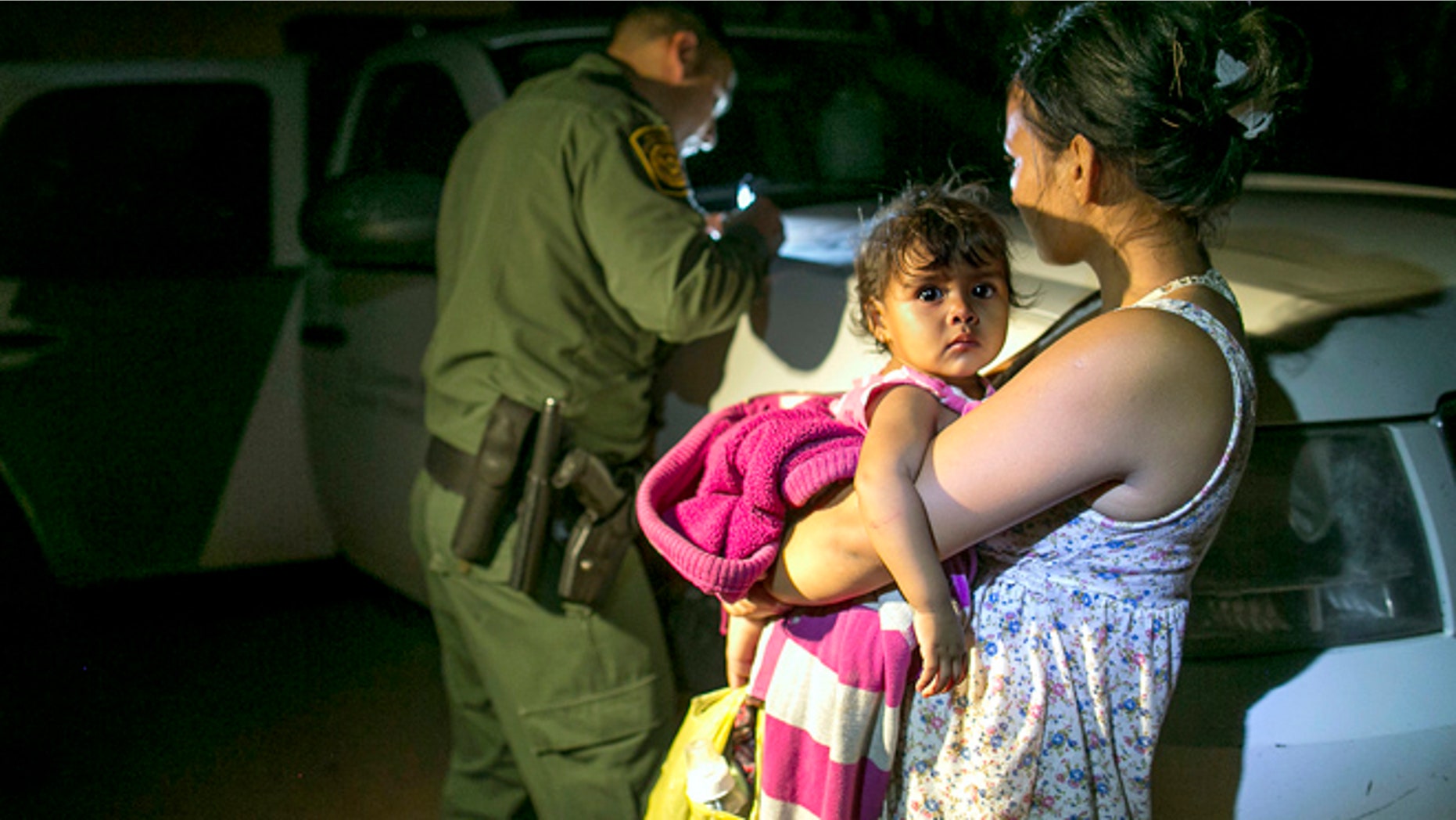 July 3, 2014: Flor Garcia, 19, of Honduras, holds her 1-year-old daughter, Flor Fernandez, after they turned themselves over to Customs and Border Protection Services agents after crossing the Rio Grande from Mexico near McAllen, Texas.
