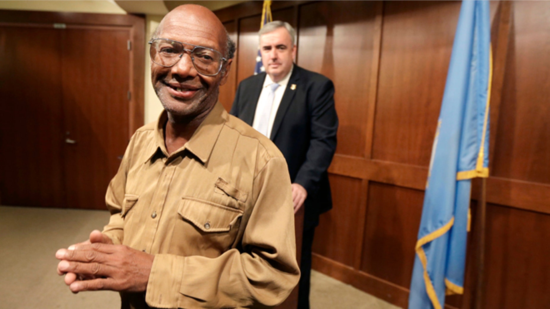Sept. 16, 2013: Glen James, of Boston, left, smiles in the direction of members of the media as Boston Police Commissioner Edward Davis, right, looks on during a news conference at the police headquarters, in Boston.