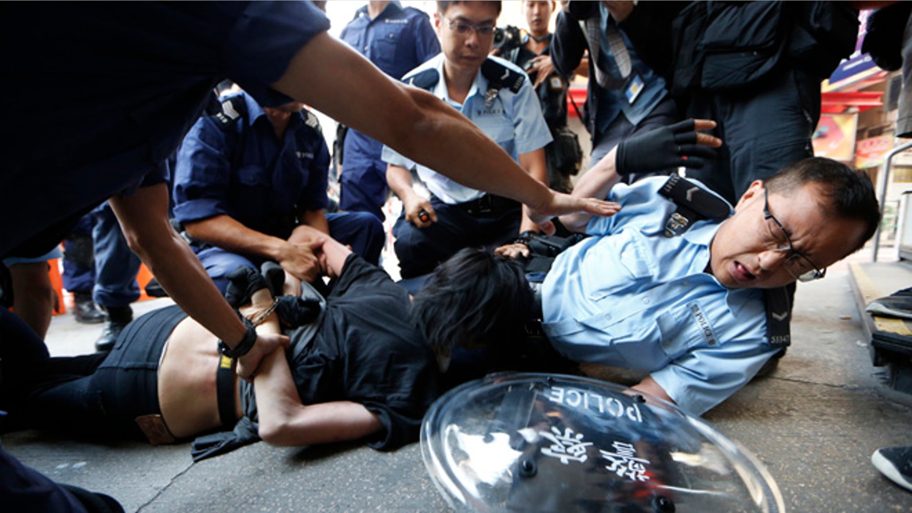 Oct. 17, 2014: A pro-democracy protester is arrested by riot police after police moved in the occupied area by the protesters in the Mong Kok district of Hong Kong. Riot police moved in on a Hong Kong pro-democracy protest zone in a dawn raid on Friday, taking down barricades, tents and canopies that have blocked key streets for more than two weeks.