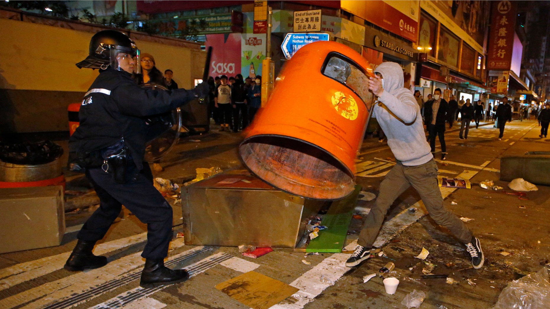 Feb. 9, 2016: A rioter tries to throw a litter bin at police on a street in Mong Kok district of Hong Kong. (AP Photo/Kin Cheung)