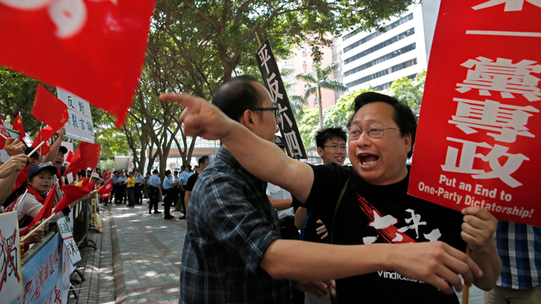 May 18, 2016: A pro-democracy activist, right, waves a banner and shouts slogans against pro-government protesters, left, outside the convention center where the Chinese Communist Party's third-highest ranking official, Zhang Dejiang, gave a speech during a visit to Hong Kong.