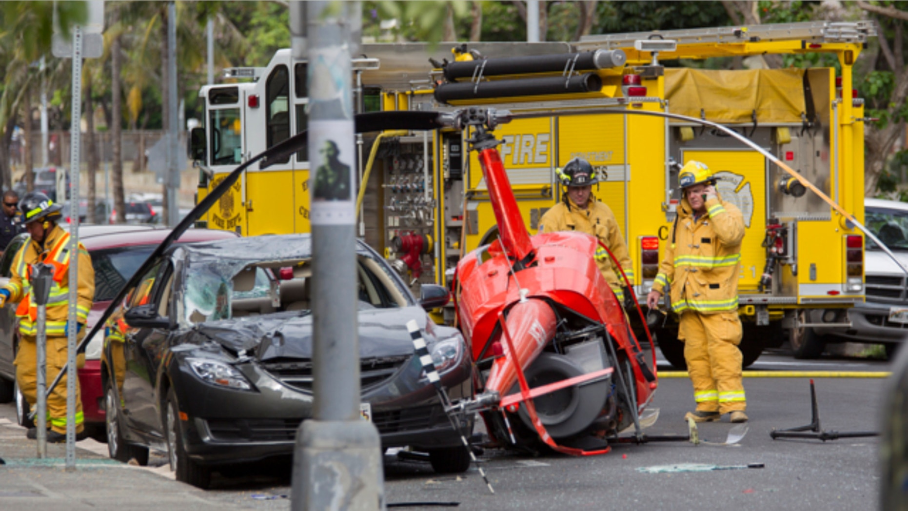 May 8, 2013: Honolulu firefighters look over the wreckage of a small helicopter that crashed next to a car near the intersection of Fort Street and Beretania Street in downtown Honolulu.