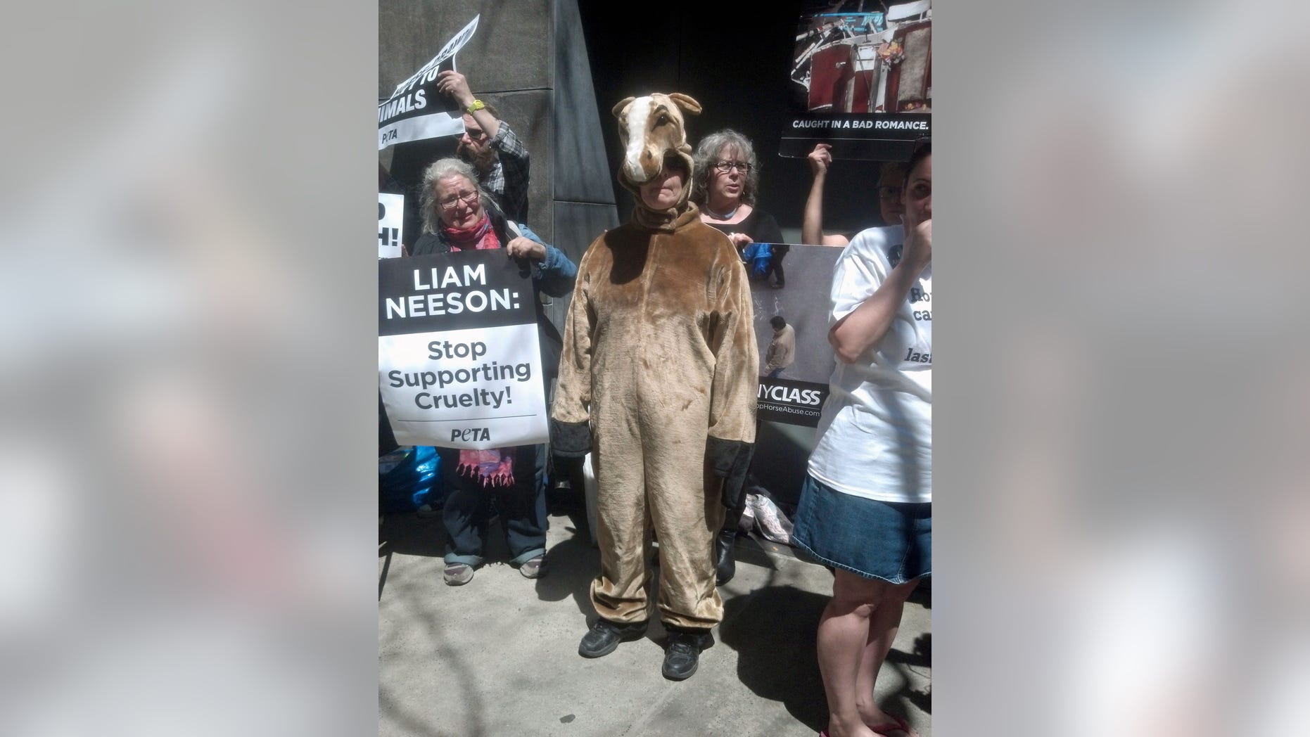 April 19, 2014. Dressed as a horse, Lisa Jablow, center, a member of NYCLASS which opposes use of carriage horses in New York City, joins other animal rights activists outside actor Liam Neeson's home to protest his stance on the continued use of carriage horses in Central Park and certain roads around the city.