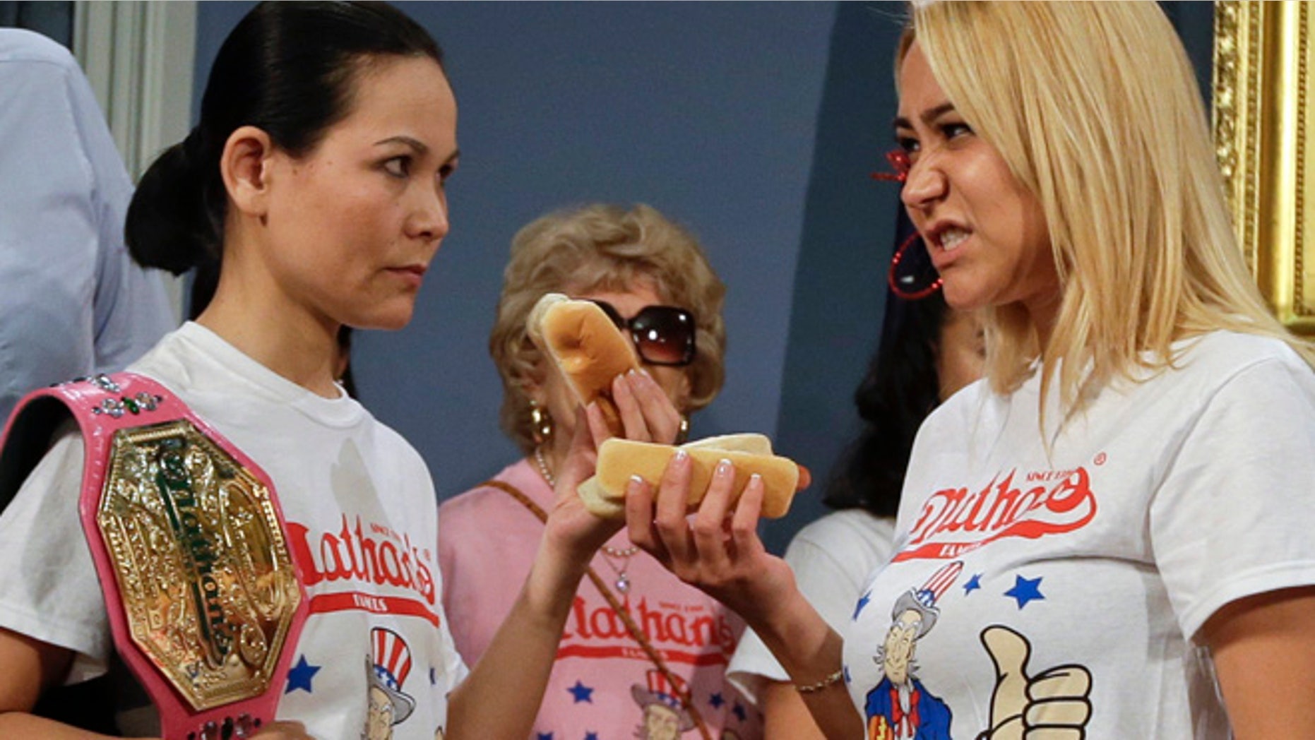 July 3, 2014: New York City Mayor Bill de Blasio watches hot dog eating contestants Sonya Thomas, left, and Miki Sudo, right, during a news conference to promote the upcoming Nathan's Famous Fourth of July Hot Dog Eating Contest.