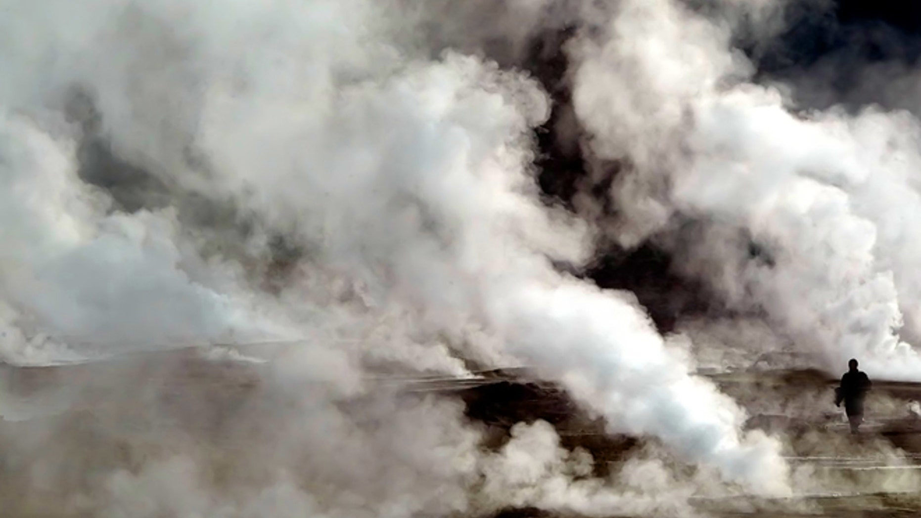 FILE: A tourist walks between the geysers and hot springs of El Tatio on March 23, 2005.The El Tatio Geyser Field (known as Los Geisers del Tatio) is located within the Andes Mountains in the Atacama Desert, Chile.