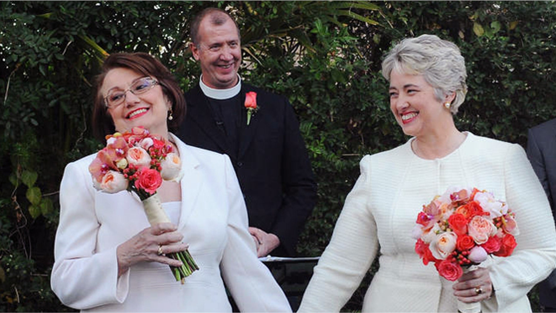 In this photo provided by the Houston mayor's office, Houston Mayor Annise Parker, right and her long-time partner, First Lady Kathy Hubbard, celebrate at their wedding Thursday, Jan 16, 1014 in Palm Springs, Calif. The ceremony was performed by the Rev. Paul Fromberg, rear, rector of St. Gregory of Nyssa Episcopal Church in San Francisco. (AP/Houston Office of The Mayor, Richard Hartog)