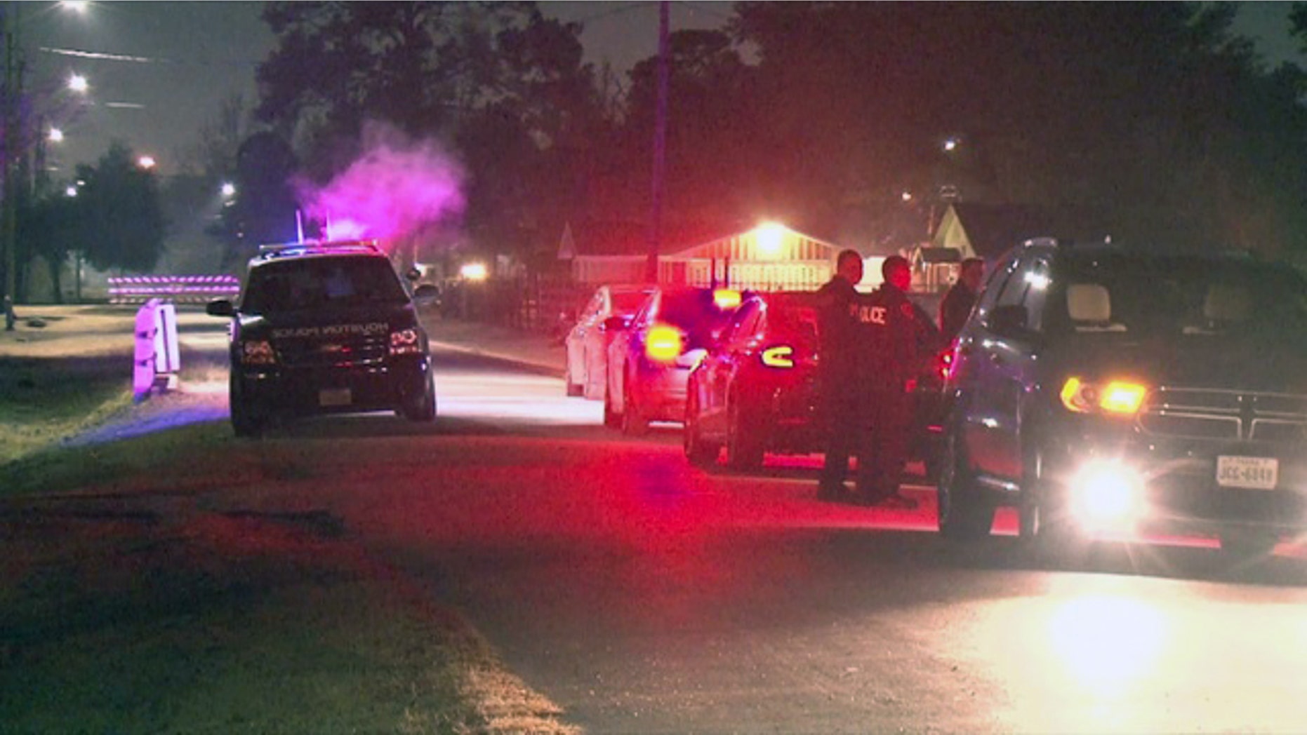Law enforcement officers wait outside the Houston home where a kidnapping victim was killed early Thursday.