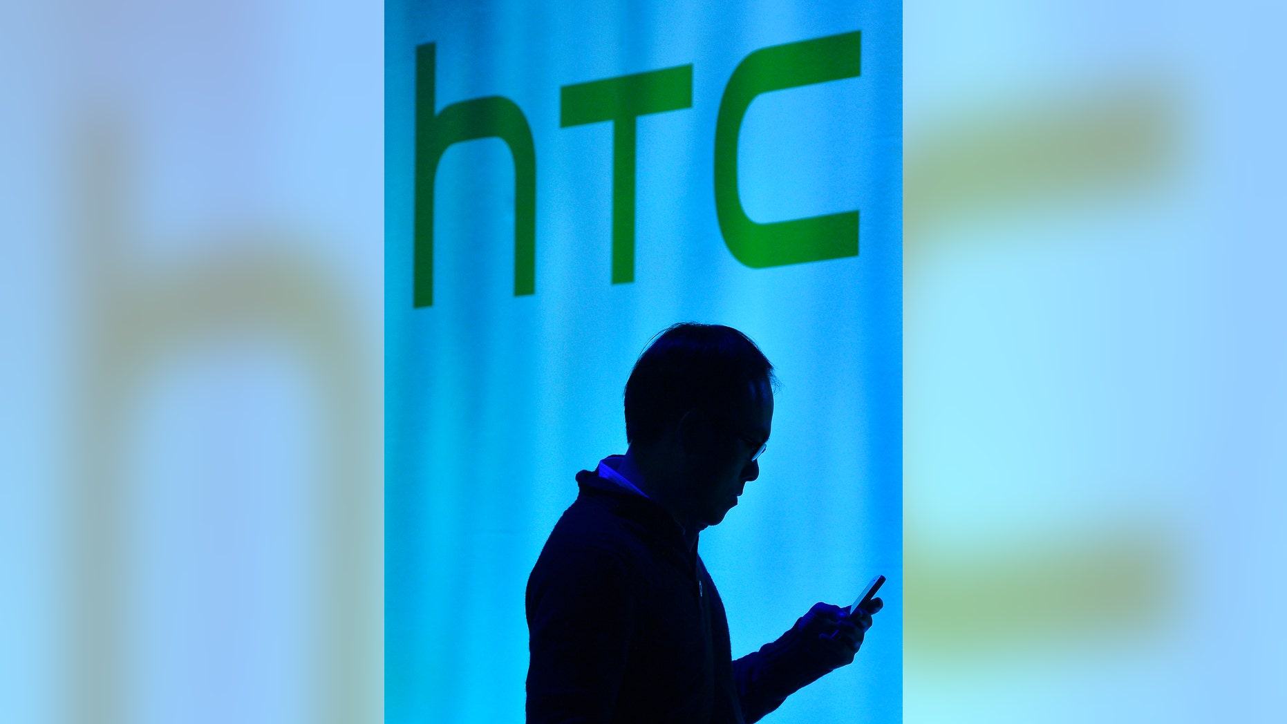 File photo - A man uses his mobile phone during the launch of the HTC One smartphone in London Feb. 19, 2013. (REUTERS/Toby Melville)