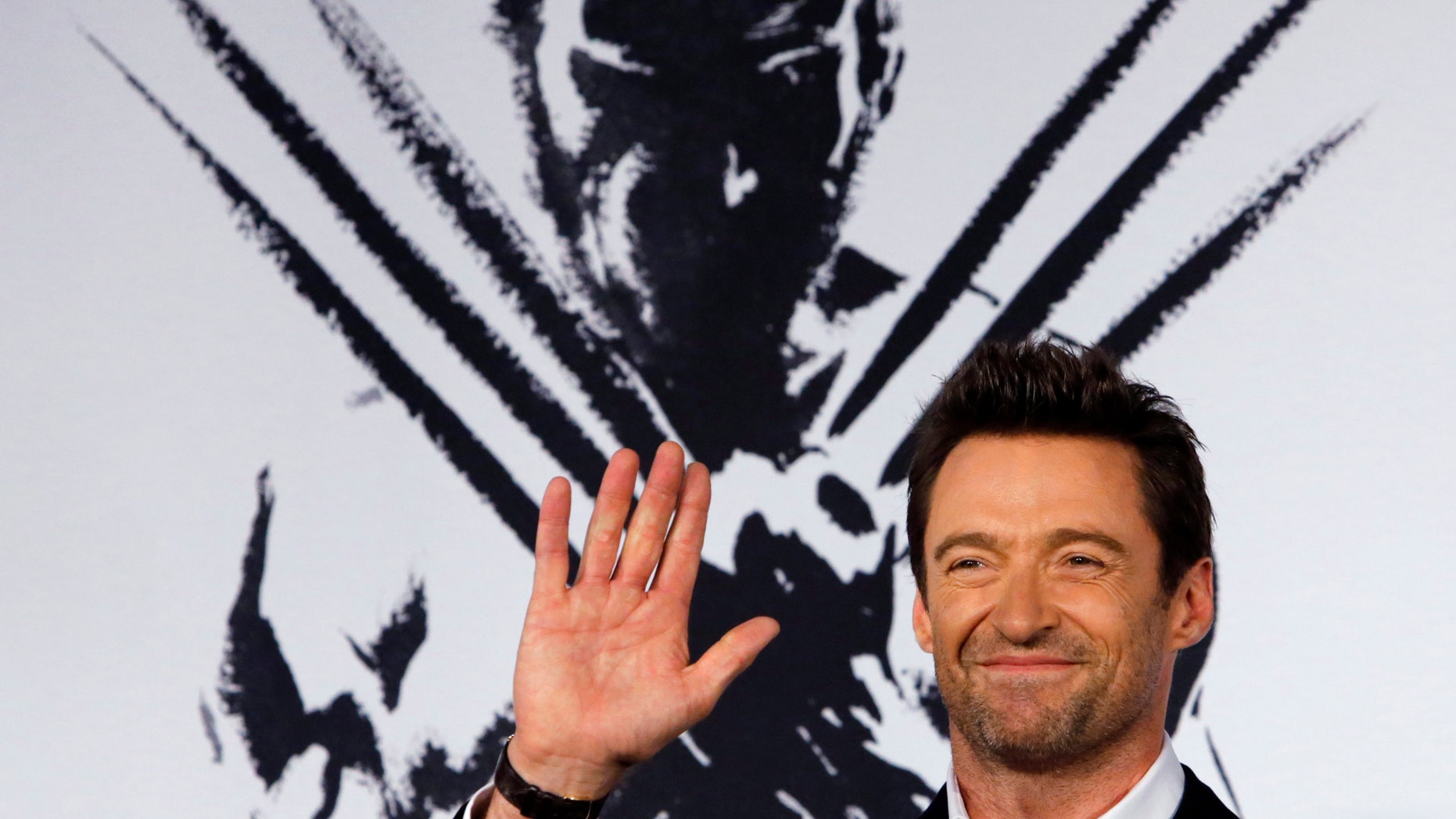 August 28, 2013. Hugh Jackman waves to fans as he attends the Japan premiere of his movie "The Wolverine" in Tokyo.