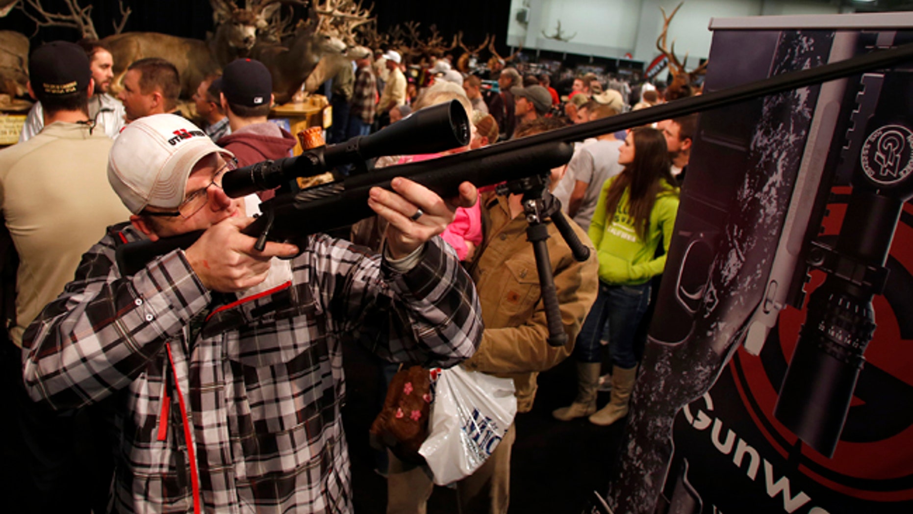 Gun and hunting enthusiast Shawn White holds a rifle while looking at weapons at the Western Hunting and Conservation Expo in Salt Lake City, Utah.