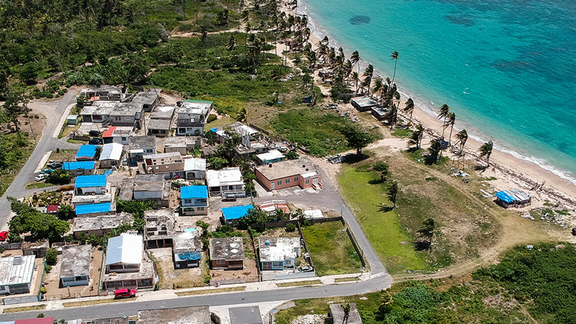 This June 18, 2018 file photo shows an aerial photo of the Viequez neighborhood, east of San Juan, Puerto Rico, where people were still living in damaged homes, protected by blue plastic tarps, nine months since Hurricane Maria devastated the island