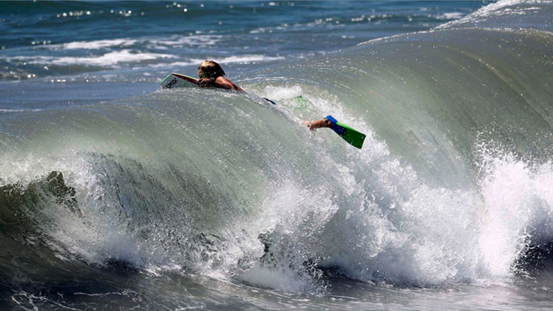 Aug. 26, 2014: A body surfer swims through a wave at Seal Beach, Calif. Residents in Southern California coastal areas filled sandbags and built sand berms Tuesday to ward against possible flooding from big and potentially damaging surf spawned by Hurricane Marie off Mexico's Pacific coast.