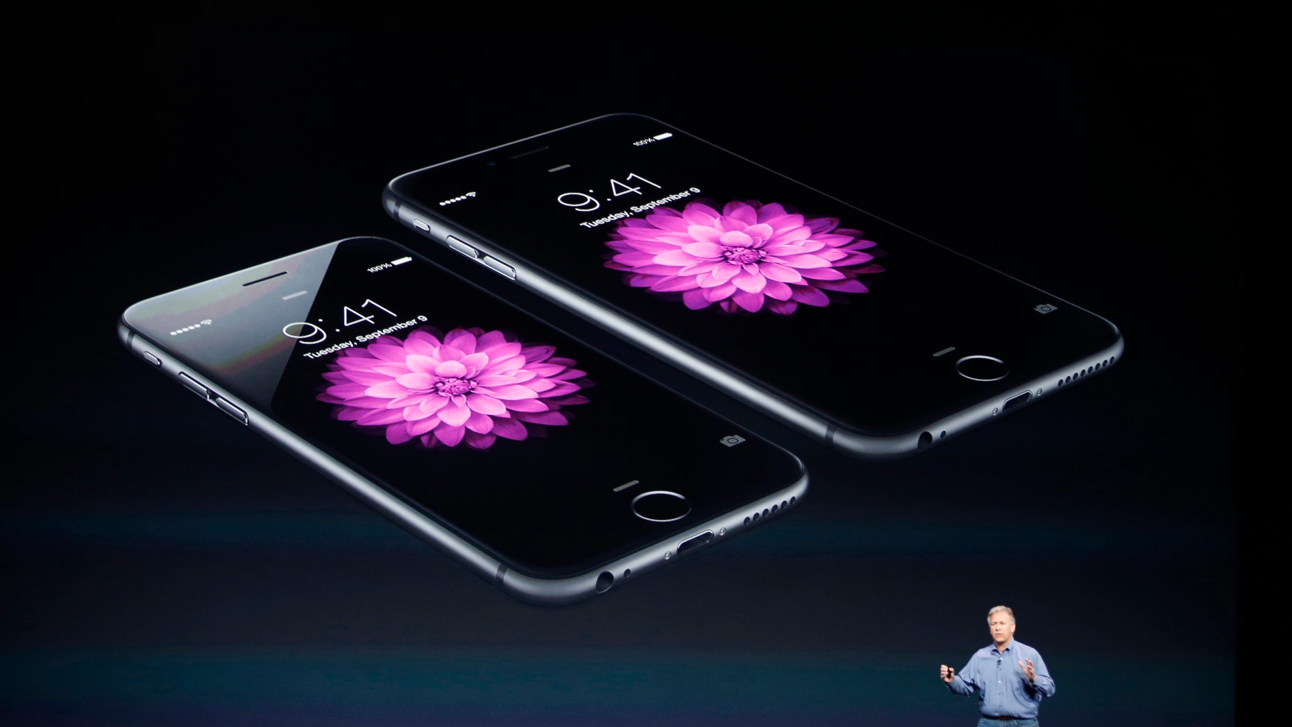 Phil Schiller, Senior Vice President at Apple Inc., speaks about the iPhone 6 (foreground) and the iPhone 6 Plus during an Apple event at the Flint Center in Cupertino, California, September 9, 2014. REUTERS/Stephen Lam (UNITED STATES - Tags: BUSINESS SCIENCE TECHNOLOGY TELECOMS) - RTR45LG0