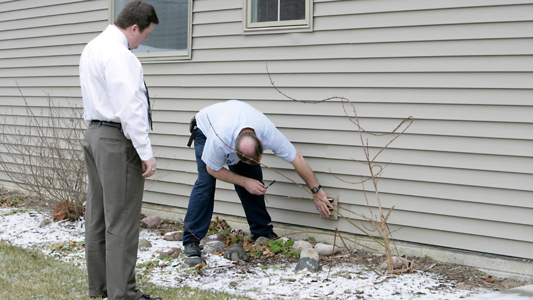 An appraiser checks out the exterior of a house.