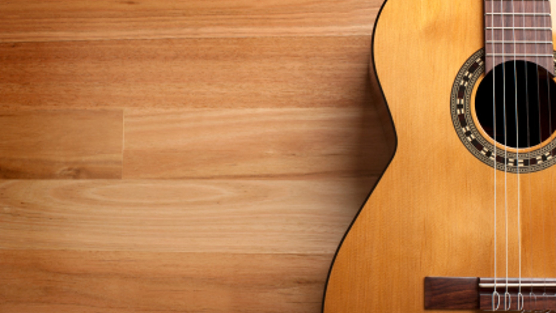 Acoustic guitar with wood background and copy space.