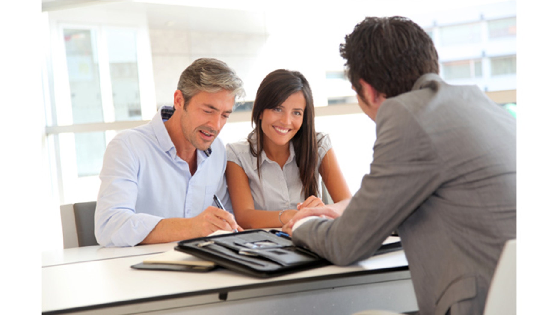 Father and teenager signing loan contract