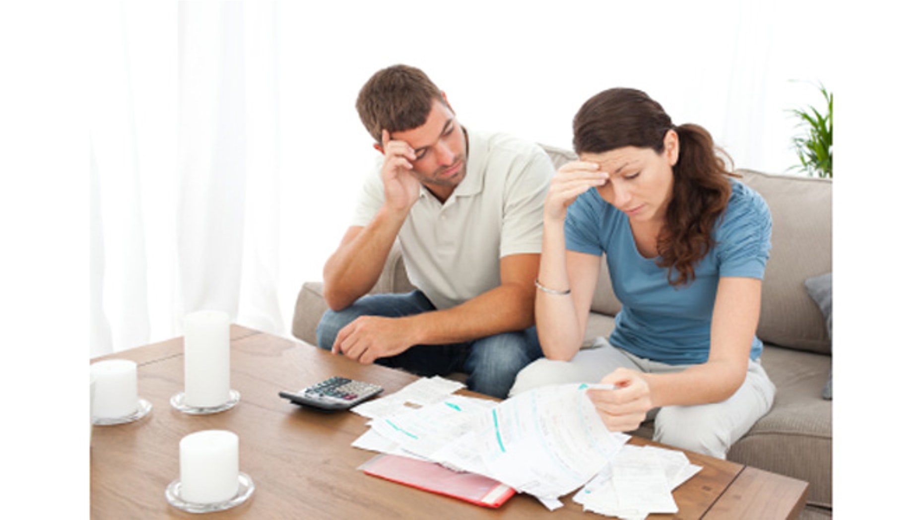 Worried couple doing their accounts in the living room at home
