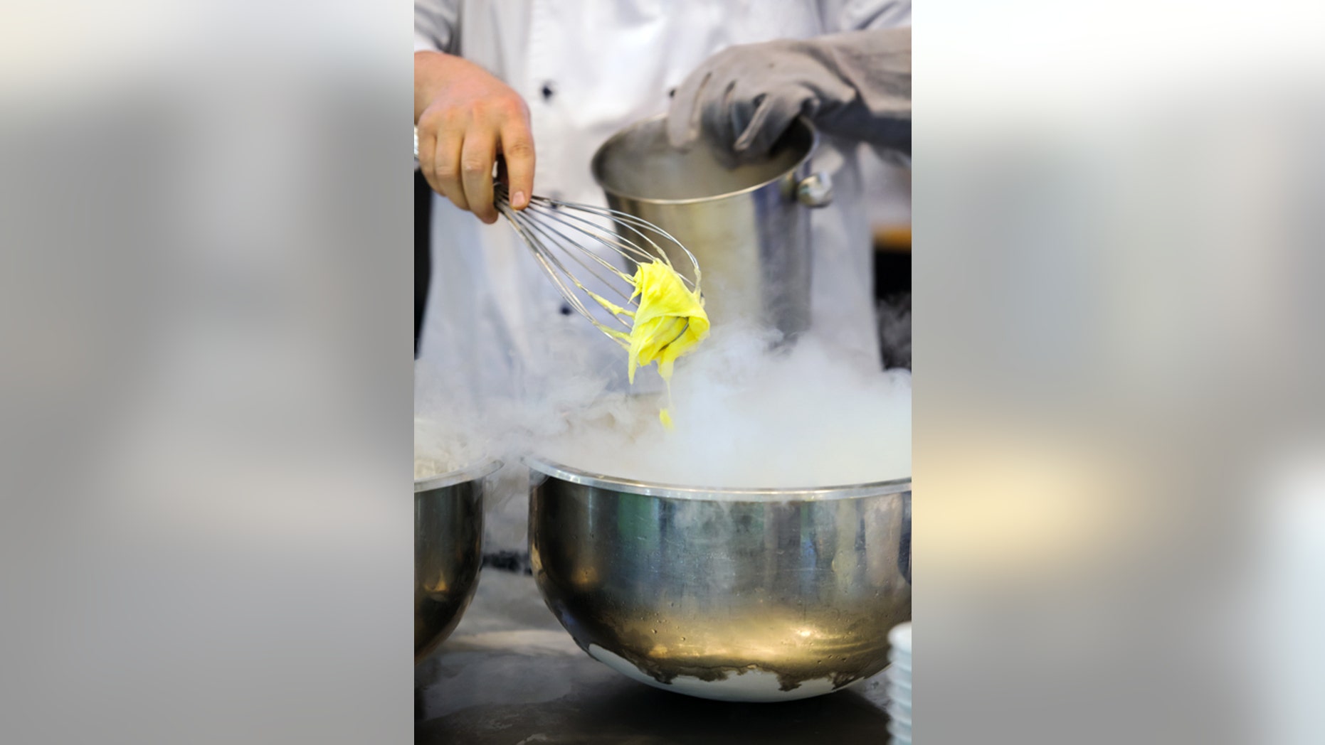 Chef preparing ice cream, using dry ice ang wire whisk, copy space