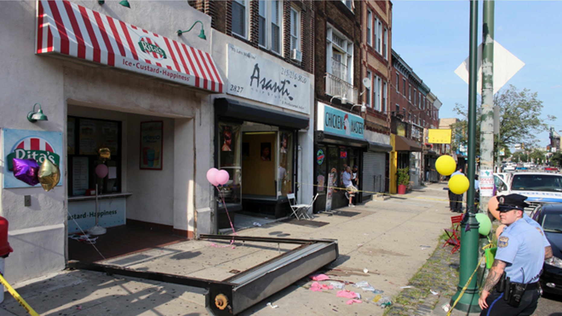 June 28, 2014: Investigators look over the debris of a fallen security door outside a Rita's Water Ice store in the Brewerytown section of Philadelphia.