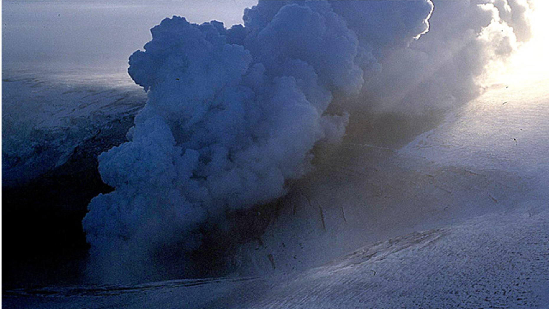 In this 2004 file photo, a cloud of ash erupts from Grimsvotn, a lake in the middle of Vatnajokull, the biggest glacier in Iceland. Torrents of water are pouring from a glacier that sits atop Iceland's most active volcano, an indication that the mountain is growing hotter and may be about to erupt, scientists said Monday, Nov. 1, 2010.