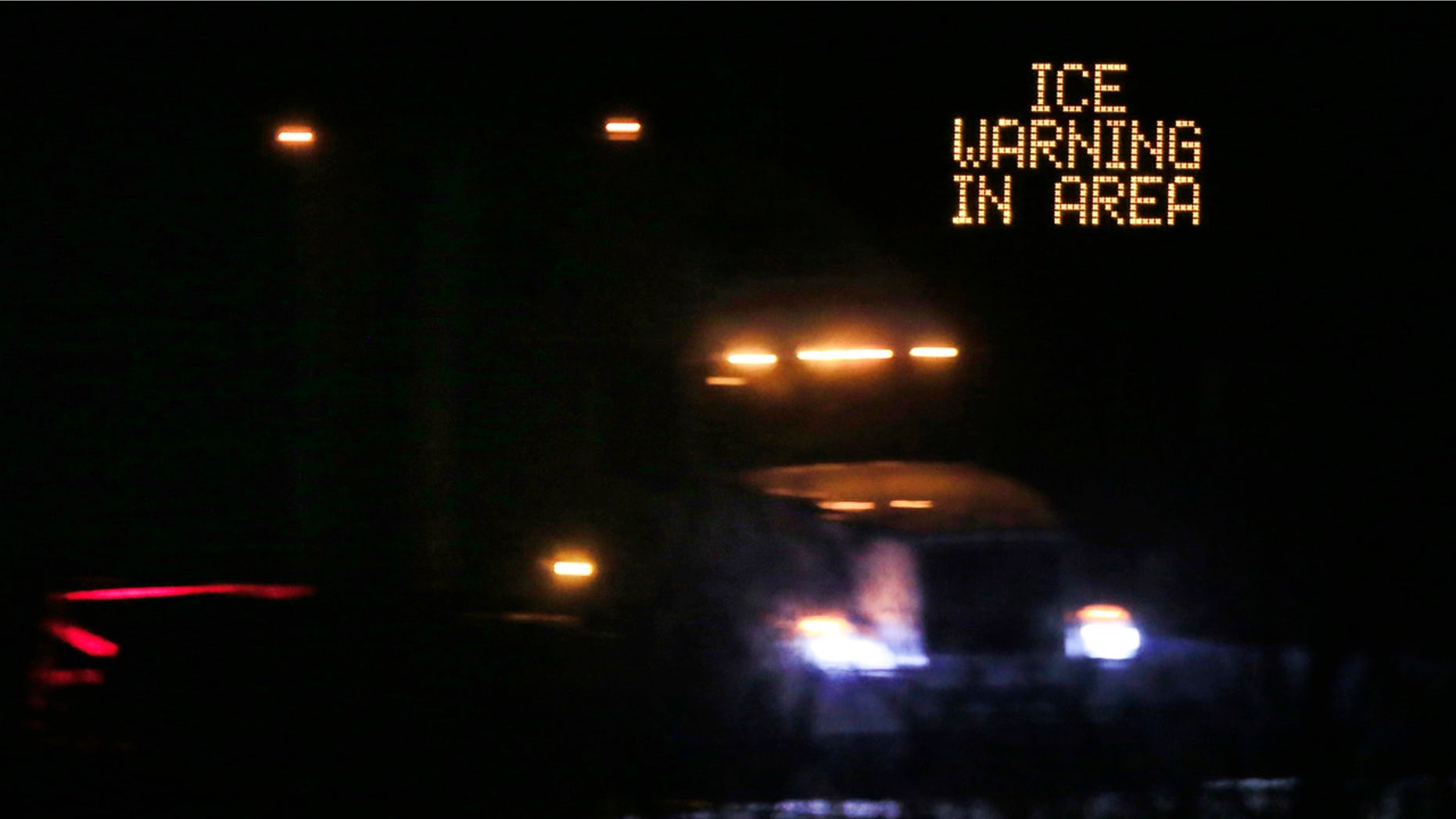 Jan. 14, 2017: Traffic moves past an icing warning sign at night on I-70 west of Lawrence, Kan.