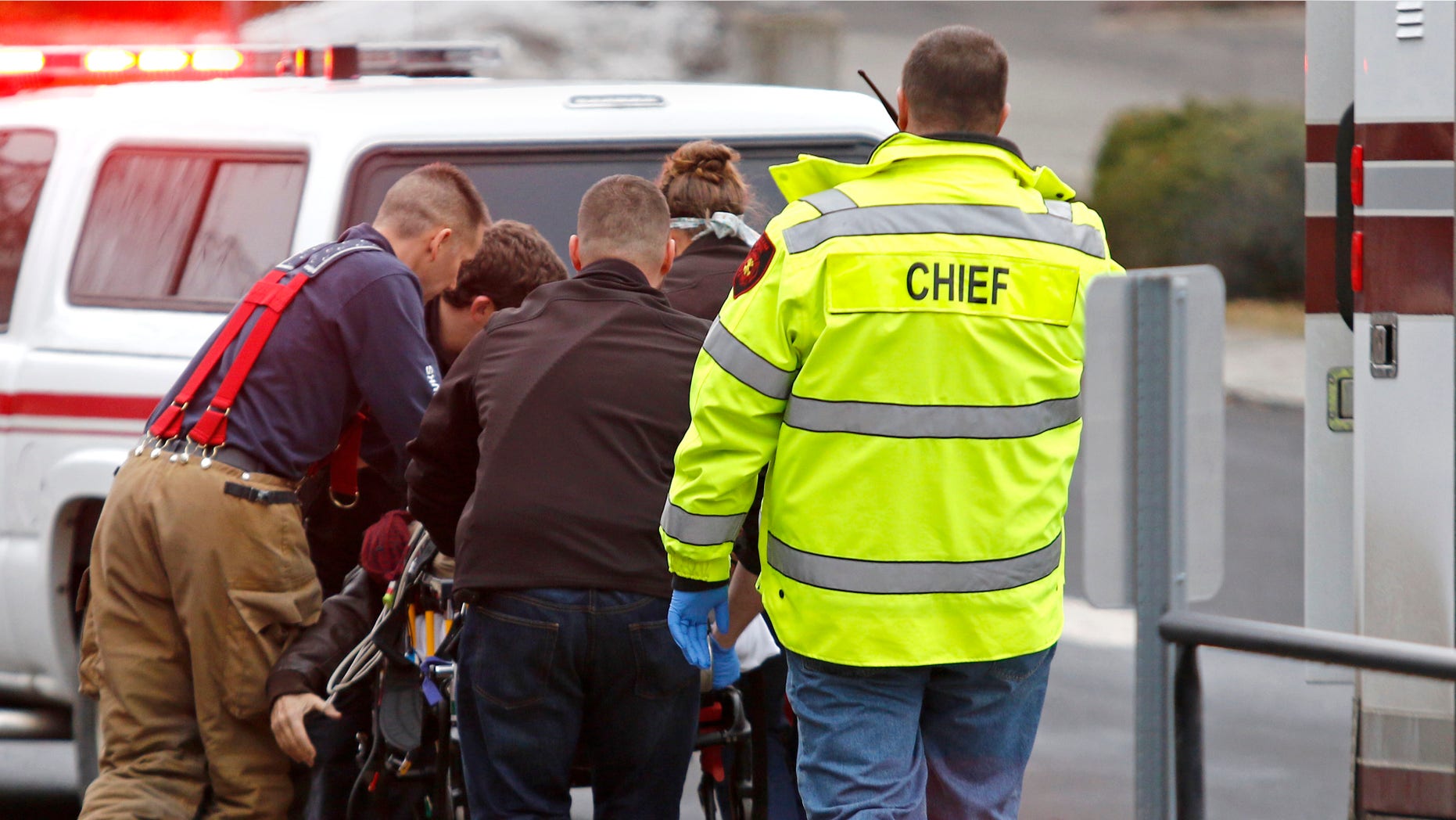 Jan. 10, 2015: Emergency medical technicians rush one of two shooting victims to an ambulance after they were shot in an office in Moscow, Idaho